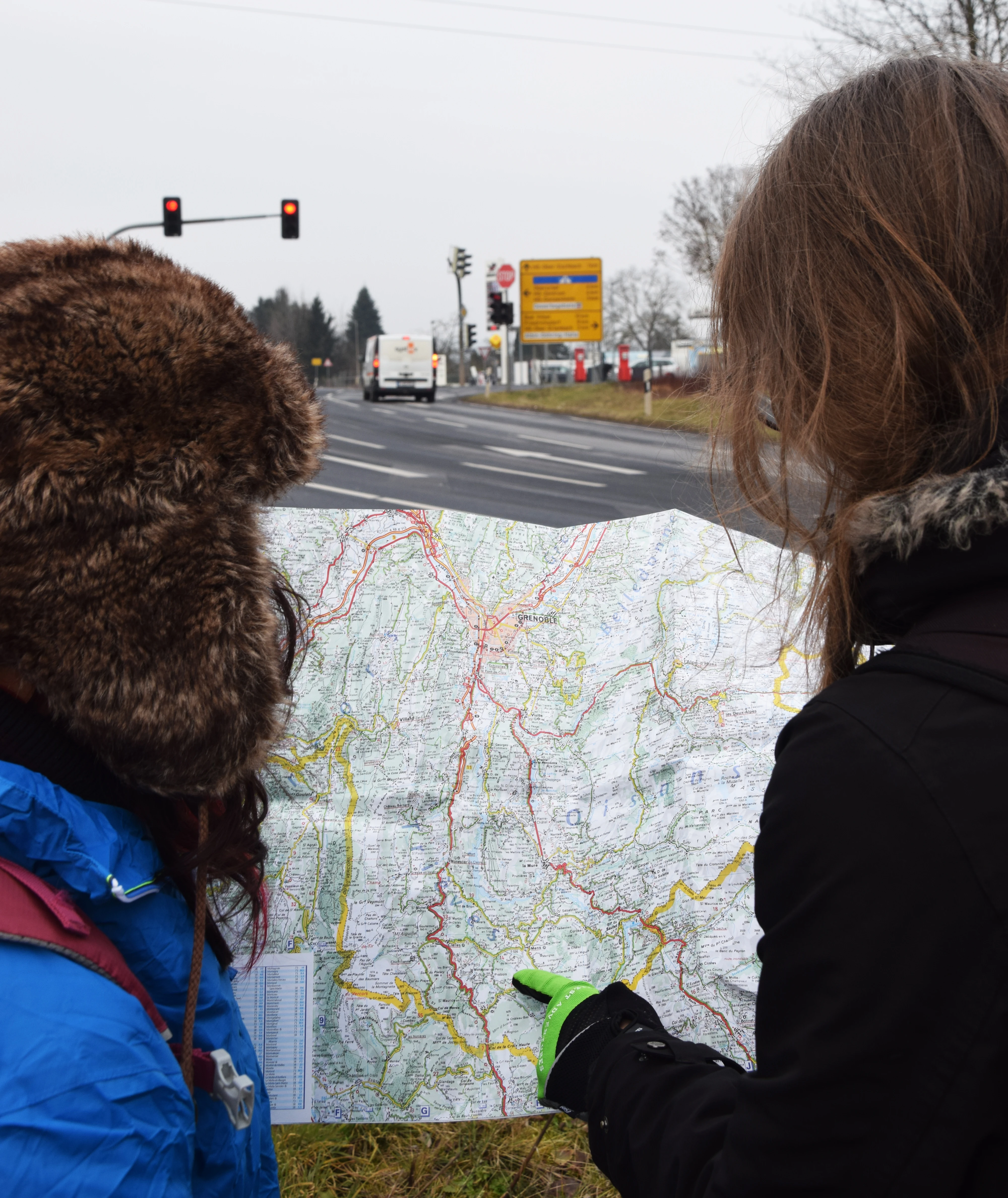 Two hitchhikers are studying a road map.